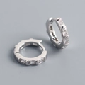 Dettaglio di orecchini in argento S925 con zirconi rettangolari e finitura lucida - Argento 925 / Oro Bianco
