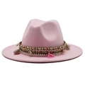 Pink wool fedora hat with bohemian tassel band and shell charm on white background - Pink