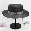 Detail of a black flat top straw hat with a sparkling silver sequin band on a stand - M (56-58cm) / Black