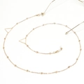 Detail of golden glasses chain with triangle charms and small metal beads on white base - Triangle