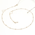Detail of gold glasses chain featuring delicate beads and heart-shaped charms - Heart