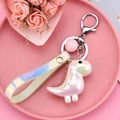 Macro detail of cute iridescent acrylic dinosaur keychain with matching wrist strap charms - Strap and Bead Style / Light Yellow