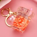 Detalle de llavero creativo con forma de taza de té con leche, fruta y líquido móvil - Taza Rojo Rosa