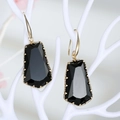 Elegantes pendientes de cristal negro con borde dorado en un soporte blanco - Negro