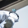 Macro shot of a six-prong round moissanite ring with a diamond-set twisted band - Adjustable Open / Twisted Shank Six-Prong Round Style (8)