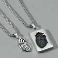 Macro shot of silver anatomical heart and square plate pendants for couples jewelry - Heart Pendant + Tag Pendant / Silver Pair