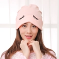Light pink knitted maternity beanie featuring black closed eyelash print for women - Smiley / Pink