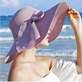 Close-up of lavender straw sun hat with large bow detail against beach background - M (56-58cm) / Purple
