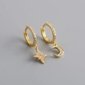 Macro shot of asymmetric gold star and moon earrings with sparkling micro-pave zircons - Gold