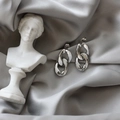 Boucles d'oreilles maillons argentés polis sur soie grise avec sculpture classique - Argenté