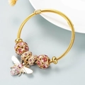 Adjustable gold rope bangle with pink zircon beads and sparkling rhinestone bee charm - Pink
