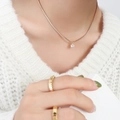 Elegant 18k gold plated titanium necklace with cubic zirconia pendant on female model - Gold