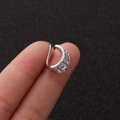 Macro di un orecchino a clip argento con diamanti scintillanti tenuto in mano - 6# Tripla Fila