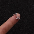 Macro shot of a silver starfish cartilage stud earring with cubic zirconia on a finger - Silver Sea Star Style (Silver 6#)