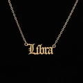 Macro shot of gold Libra zodiac pendant with gothic font and delicate chain necklace - Libra / Gold