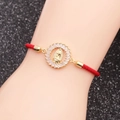 Détail d'un bracelet religieux tressé rouge avec breloque Vierge Marie dorée et zircons - Corde Tissée Rouge Vierge Marie