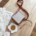 Kreative Toast Umhängetasche mit Spiegelei-Anhänger auf einem Holz-Tisch - Toastbrot Tasche + Spiegelei Anhänger / Braun
