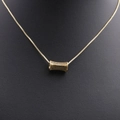 Nahaufnahme der goldenen Halskette mit Zirkonia-Anhänger auf einem schwarzen Modell - Gold