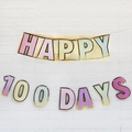 Pastel Happy 100 Days party banner with gold trim on white brick wall for baby girl birthday - Macaron Happy 100 Days Banner