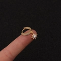 Vergoldete Creolen mit Zirkonia-Sternanhänger präsentiert auf einer Fingerspitze - Silber / Achtzackiger Stern
