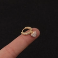 Nahaufnahme einer goldenen Herz-Creole mit schimmernder Zirkonia-Einlage für Damen - Silber / Herz