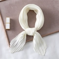 Close-up of pleated white satin neck scarf with silk texture on a display tray - White