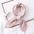 Elegant pleated light pink silk scarf arranged in a heart shape on a minimalist background - Pink