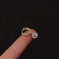 Nahaufnahme einer goldfarbenen Creole mit Zirkonia und rundem Diamant-Anhänger - Silber / Rund