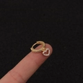 Detailansicht goldener Blitz-Ohrring mit Zirkonia-Besatz an einer Hand präsentiert - Silber / Herz