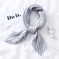 Detail of lavender pleated silk scarf with satin texture laid on a white fabric background - Silver Grey