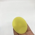 Close-up of yellow oval silicone cleansing brush with soft bristles and massage nubs - Transparent Yellow