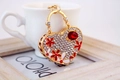 Portachiavi a cuore dorato con strass bianchi e decorazioni floreali con gemme rosse - Rosso