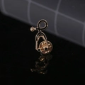 Macro shot of gold and black stethoscope enamel pin with reflections on dark mirror surface - Black