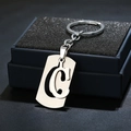 Llavero de acero inoxidable con letra C calada sobre un elegante expositor de joyas - Letra C