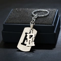 Polished stainless steel letter E keychain pendant displayed in a black jewelry box - Letter E