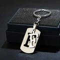 Macro view of silver stainless steel letter F keychain charm in a premium gift box - Letter F