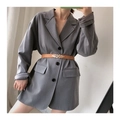 Detailed view of a brown leaf buckle belt cinched over a grey blazer for a stylish look - Camel