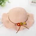 Detail of pink straw sun hat with woven wavy brim and colorful daisy flower ornaments - Hat / Pink