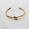 Dettaglio del bracciale rigido a nodo placcato oro 18 carati con finitura lucida - Oro