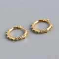 Detalle de pendientes de aro con cruz dorada, textura de perlas y estilo minimalista - Plata 925 / Color Oro (Par)