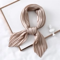 Close-up of champagne pleated satin scarf showing texture and silk luster on metal frame - Champagne
