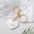 Porte-clés doré avec pendentif cœur blanc et lettre MR dorée sur papier froissé - Cœur Blanc MR