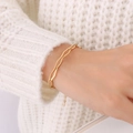 Minimalistische geometrische 18K vergulde armband gedragen op een witte gebreide trui - Gouden Geometrische Lange Ovalen Armband-E302