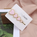 Barrette dorée élégante avec quatre cœurs en émail rose sur carte avec un fond rose doux - Rose