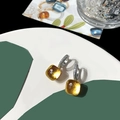 Detailed close-up of amber yellow square faceted crystal earrings with silver micro-pave - Gold