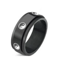 Macro detail of rotating black stainless steel ring with white Yin Yang pattern - Tai Chi Bagua Pattern Style
