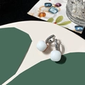 Detailed close-up of a silver earring with a white square crystal and pavé zircon stones - Milky White