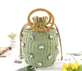Detail van groene strooien emmer tas met strass steentjes en ronde houten handvatten - Groen
