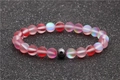 Beaded moonstone and hematite bracelet with matte pink gradient beads on a grey background - Red Pink Gradient Moonstone Hematite