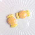 Macro shot of colorful resin candy accessories with spiral patterns on a ceramic plate - Yellow